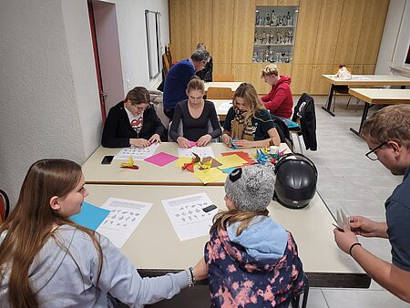 Kinder und Jugendliche des Jugendrotkreuzes (JRK) Eggenstein-Leopoldshafen basteln gemeinsam Origami-Kraniche.