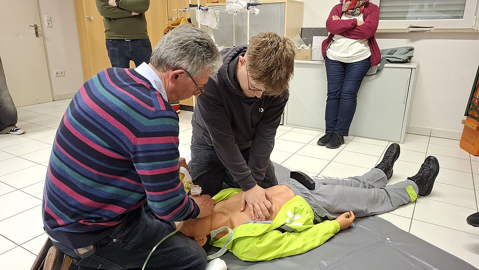 Zwei Einsatzkräfte üben die Herz-Lungen-Wiederbelebung an einer Puppe.
