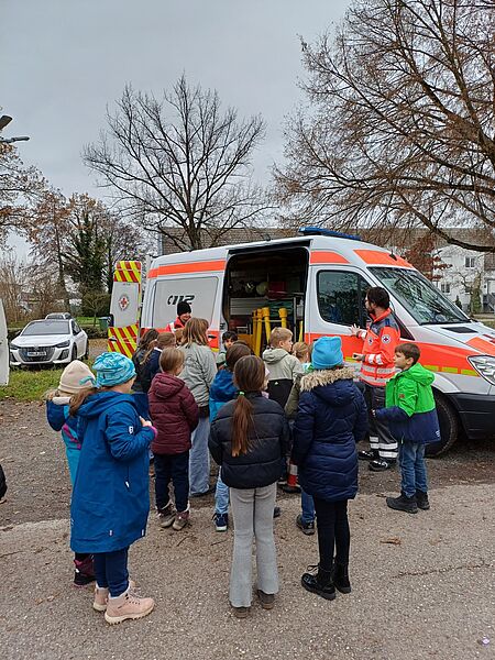 Pädagogischer Tag der Lindenschule: Schülerinnen und Schüler erhalten Einblicke in die Einsatzfahrzeuge des DRK Eggenstein-Leopoldshafen e.V. Zwei Mitglieder des DRK Eggenstein-Leopoldshafen e.V. zeigen den Schülern ein Einsatzfahrzeug.